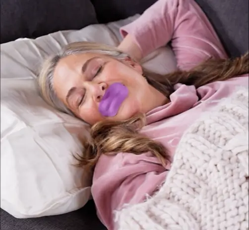 Sleep Shield mouth tape on nightstand beside pillow – promoting restful sleep and nasal breathing.